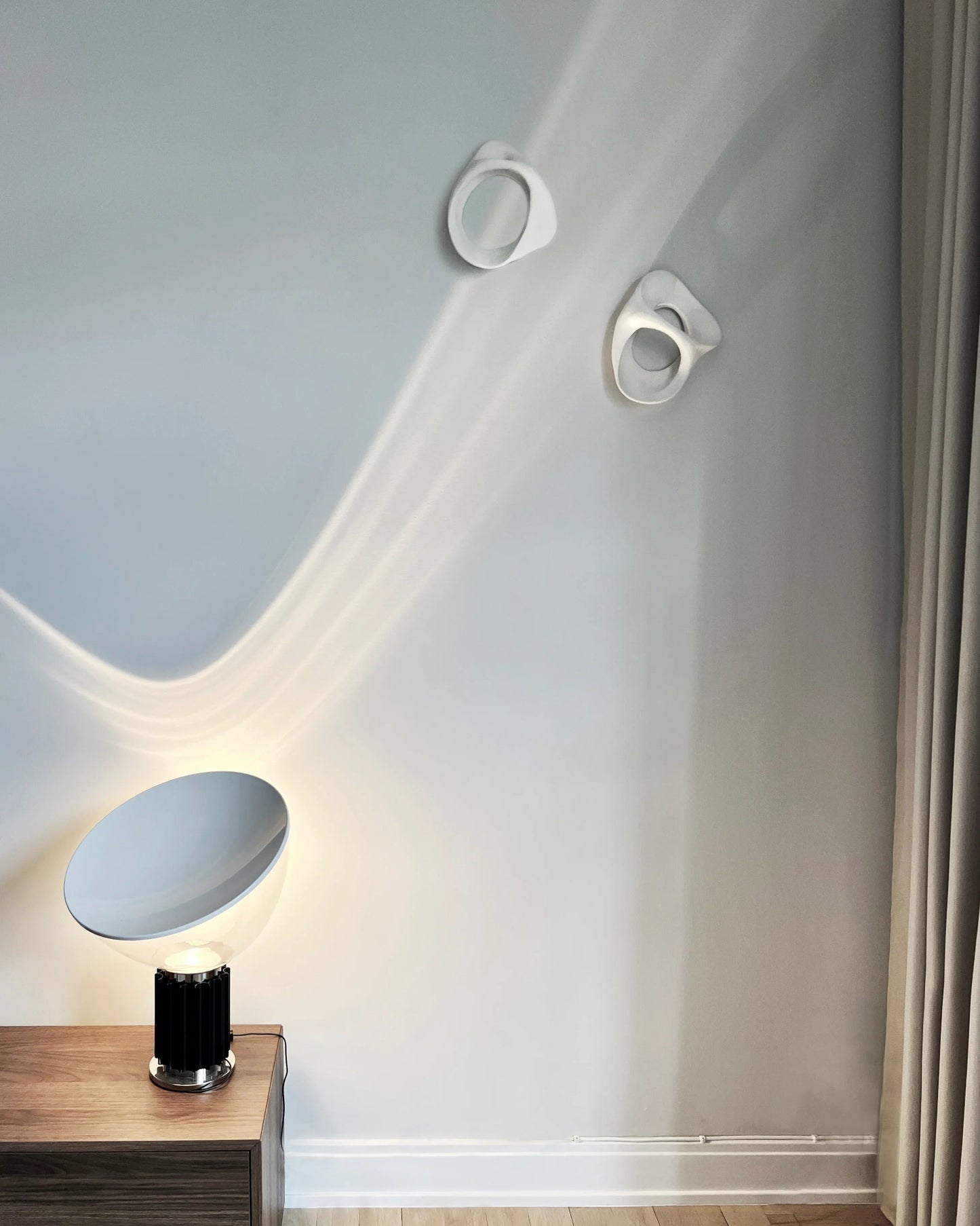 Abstract white hanging sculptures against a white wall