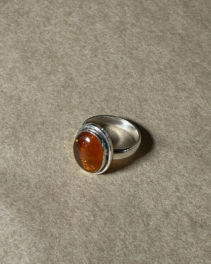 Silver ring with a amber stone on a gray background